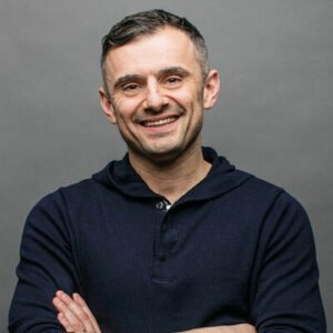 Gary Vaynerchuk smiling confidently in a navy hoodie with arms crossed, against a clean studio background.